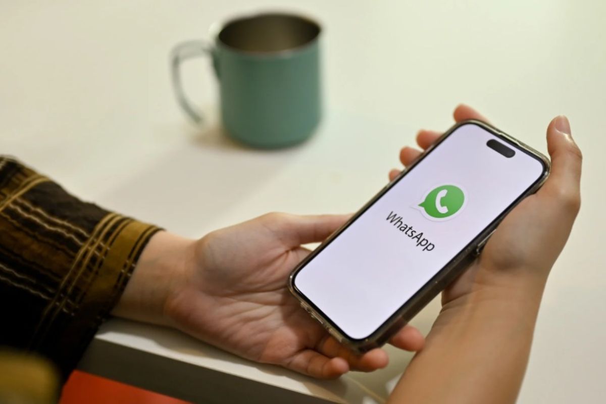 tra le mani uno smartphone con logo whatsapp